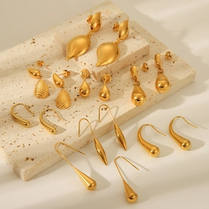 Collection of water drop and geometric 18K gold plated stainless steel earrings on marble