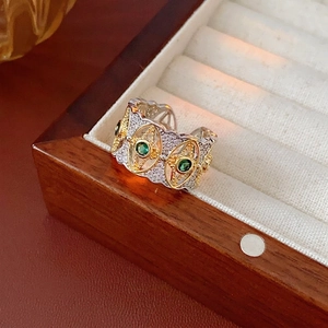 Anello bicolore con gemme verdi, motivo a stella e design geometrico traforato di lusso