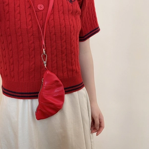 Gros plan sur un mini-sac à cou rouge en forme de croissant avec design plissé