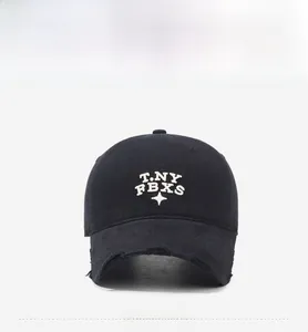 Detail of black washed baseball cap with white 3D embroidery and distressed frayed brim