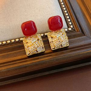 Detailed macro of vintage red square stud earrings featuring white cubic zirconia accents