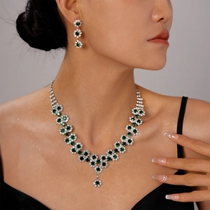Detail of luxury multilayer sunflower necklace and earrings with sparkling green gemstones