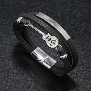 Detail of multi-layer leather bracelet with guitar charm and magnetic metal buckle