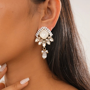 Detail of luxury rhinestone earrings with pearls and white opal drop on model
