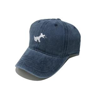 Close-up of navy washed cotton baseball cap with white dog embroidery and curved brim