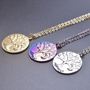 Three round Tree of Life pendants in gold, silver and aurora finishes on fine chains
