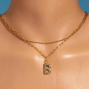 Detailed close-up of double-layer gold necklace with letter B cubic zirconia pendant