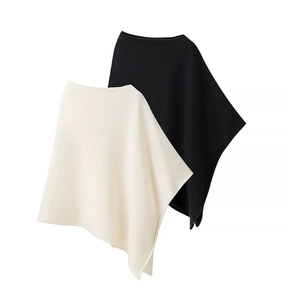 Detail showing the fine knit texture and irregular hem of black and beige ponchos