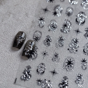 Gothic nail stickers with silver metal snakes and moon patterns on a dark background