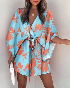 Detail of light blue V-neck dress with orange floral print and drawstring waist