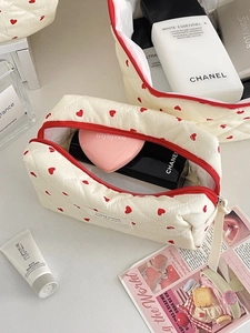 Detailed view of quilted makeup bag with red hearts and premium beauty accessories