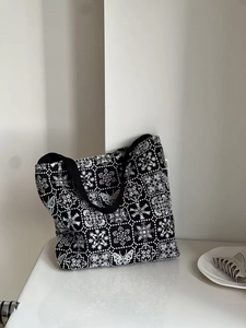 Detailed close-up of butterfly embroidery and vintage patterns on a canvas tote bag