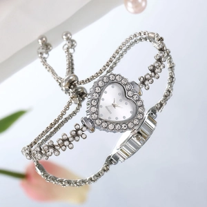 Détail de montre quartz en forme de cœur avec strass et bracelet à maillons floraux