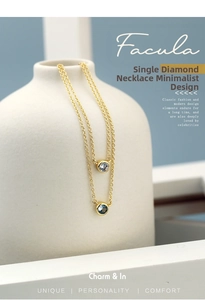 Detailed macro view of gold chain necklaces with blue round zircon pendants on a white vase