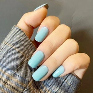 Glossy sky blue almond press-on nails on hands with gray plaid sleeve cuff