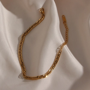 Detail of gold Cuban link chain set with K18 stamp, lobster clasp, and extender