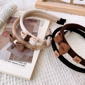 Maillard style knitted bow headbands in coffee colors on an open vintage book