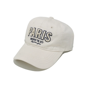 Détail de la casquette en coton blanc cassé avec broderie PARIS bleue et coutures précises
