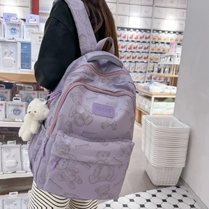 Dettaglio dello zaino viola chiaro con stampa orso, tessuto in nylon e ciondolo morbido