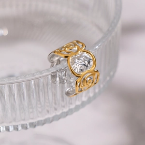 Macro detail of two-tone rose flower engraved ring on a ribbed glass holder
