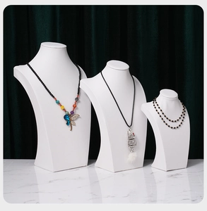Necklace display featuring dragonfly pendant and rhinestone fish on white mannequins