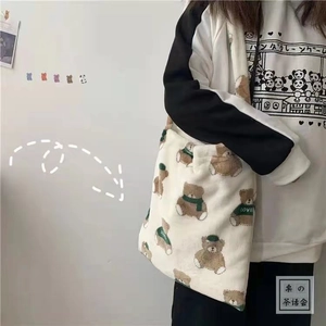 Detail of white plush shoulder bag featuring cute brown bear with green scarf and LOVE text