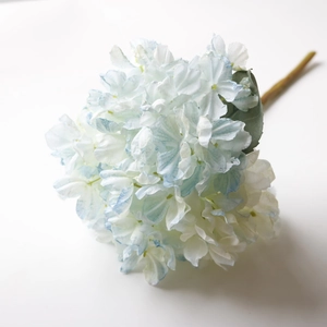 Detailed macro shot of white artificial hydrangea petals with delicate blue edges