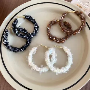 Trois paires de créoles géométriques en laine tricotée, coloris noir, caramel et crème