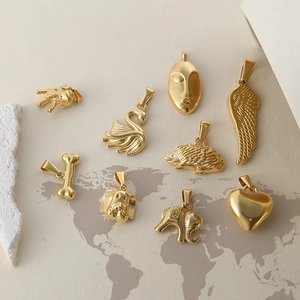 Set of nine 24k gold plated stainless steel pendants including elephant and heart shapes