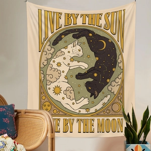 Detail of bohemian cat tapestry with sun and moon text on a minimalist wall