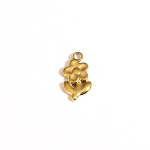 Detailed view of a polished golden floral and leaf shaped titanium steel pendant
