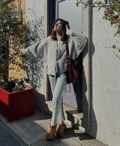 Street style view of a light gray fuzzy cardigan with front tie and blue high-waist jeans