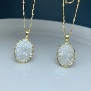 Golden oval pendant necklace with white mother of pearl Virgin Mary relief engraving