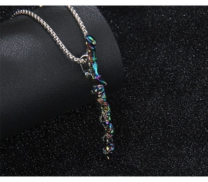 Close-up of rainbow colorful dragon sword pendant with silver metal chain on dark leather