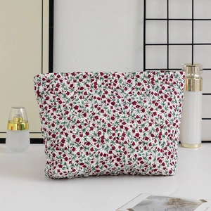 Detailed view of floral quilted makeup bag with red flower pattern and metal zipper
