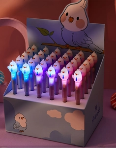 Detail showing the glowing LED tip of bird-shaped gel pens in a pink display box