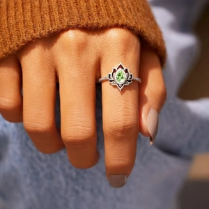 Vintage silver lotus ring featuring a pear-cut green gemstone and intricate diamond accents