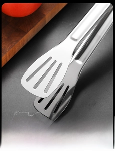 Macro detail of stainless steel food tongs with hollow slots on polished mirror surface
