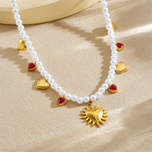Gold-plated pearl necklace with red heart pendants and a central sun-heart charm