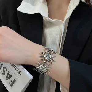 Detailaufnahme eines stilvollen silbernen Metallarmbands mit Sonnenmotiv am Handgelenk