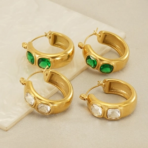Detail of 18k gold plated stainless steel chunky hoop earrings with emerald and clear gems