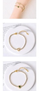 Close-up of gold plated heart bracelets with sparkling white and green zircon stones
