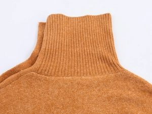 Dettaglio del maglione a collo alto giallo zenzero che mostra la trama a costine di qualità