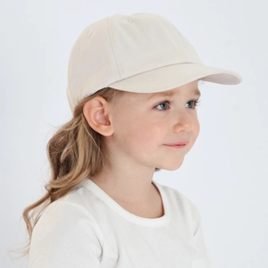 Detailed side view of a beige cotton baseball cap for kids with a curved visor
