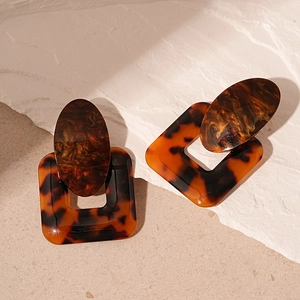 Macro shot of tortoiseshell resin geometric earrings with oval and square elements