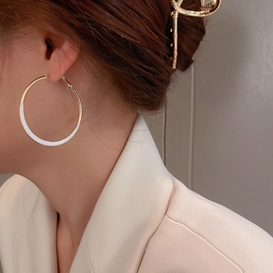 French style white enamel hoop earrings and gold bamboo hair clip on a female model