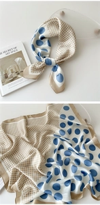 Detail view of stylish blue and beige polka dot silk scarf with smooth satin texture