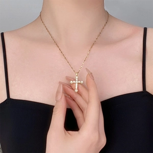 Collier à pendentif croix dorée avec micro-pavé de zircons sur une chaîne fine