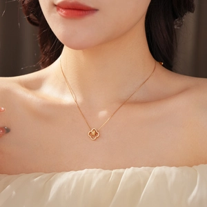 Detail of 18K gold plated clover necklace with sparkling cubic zirconia on model