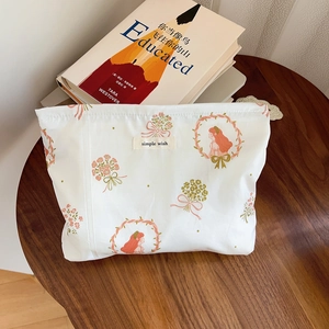 Close-up of a floral cotton makeup bag with 'simple wish' label on a vintage wooden table